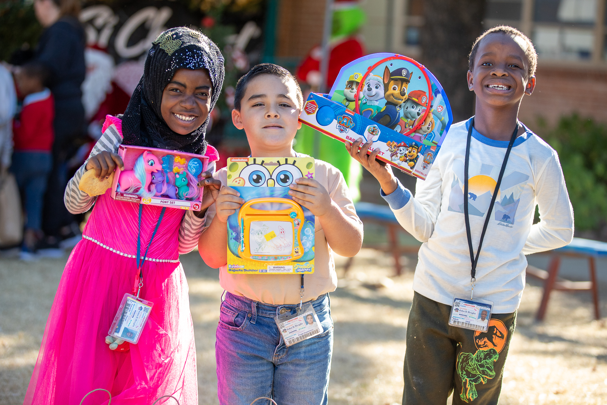 A group of three kids hold up their new toys