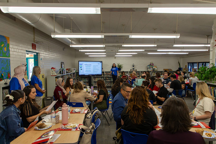 A group of people sitting around tables discussing AVID