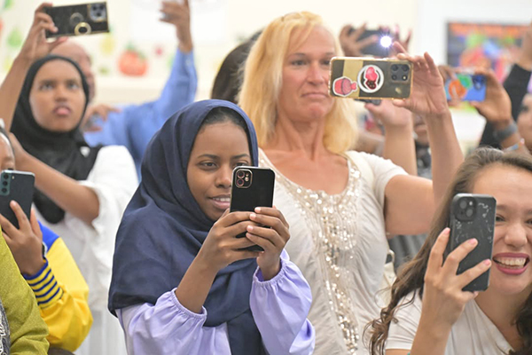 Family members hold up their phones to capture videos of the kinder promotion