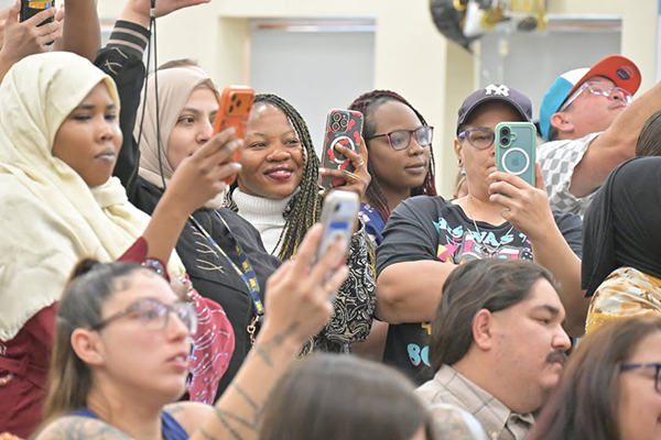 Family members hold up their phones to capture photos of the kinder promotion ceremony